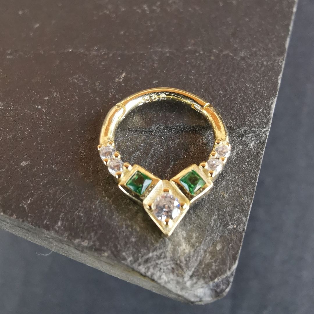 Premium septum piercing jewelry with a unique ring design highlighted by a captivating green gem.