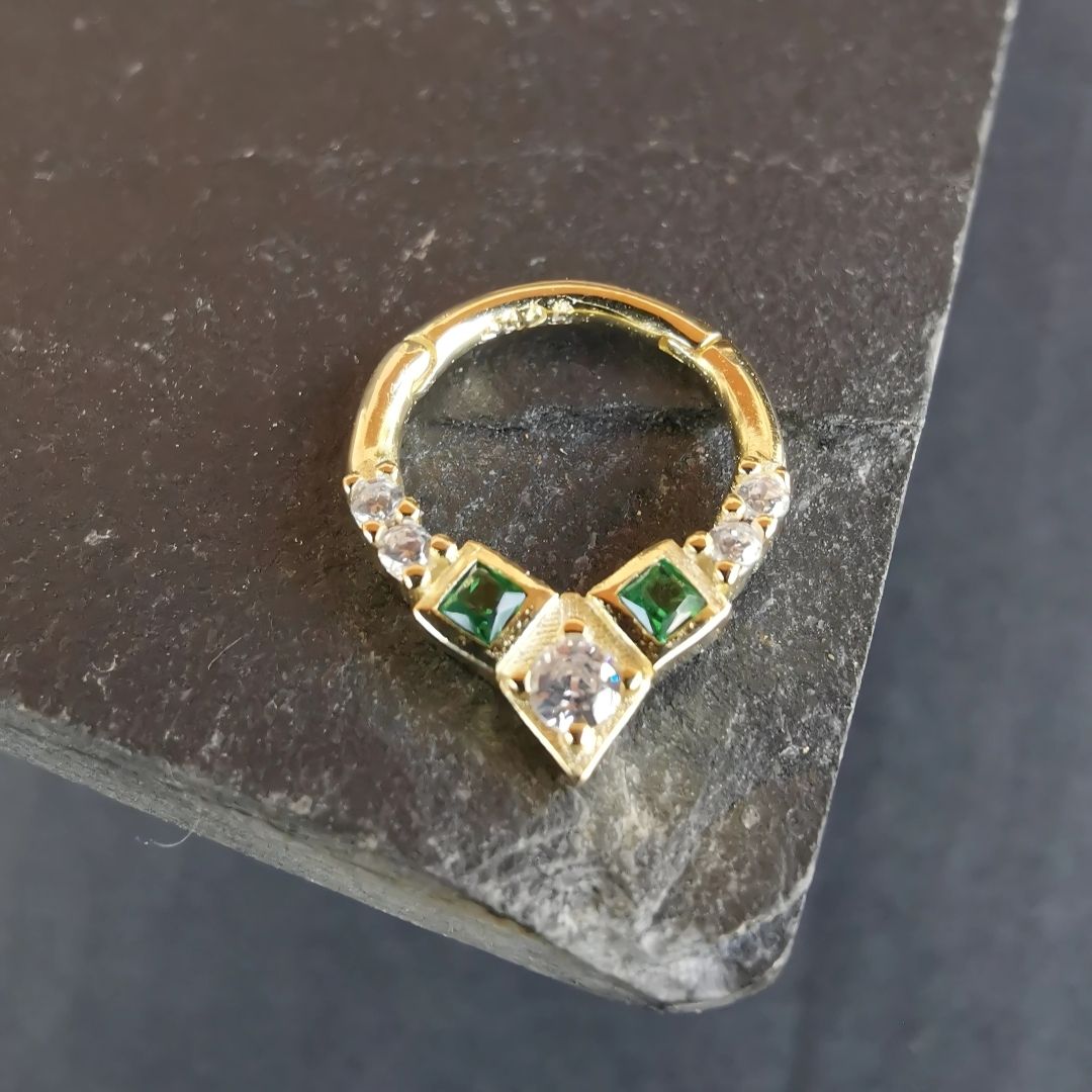 Modern daith ring piercing piece with a vibrant green gem for a bold, eye-catching look.