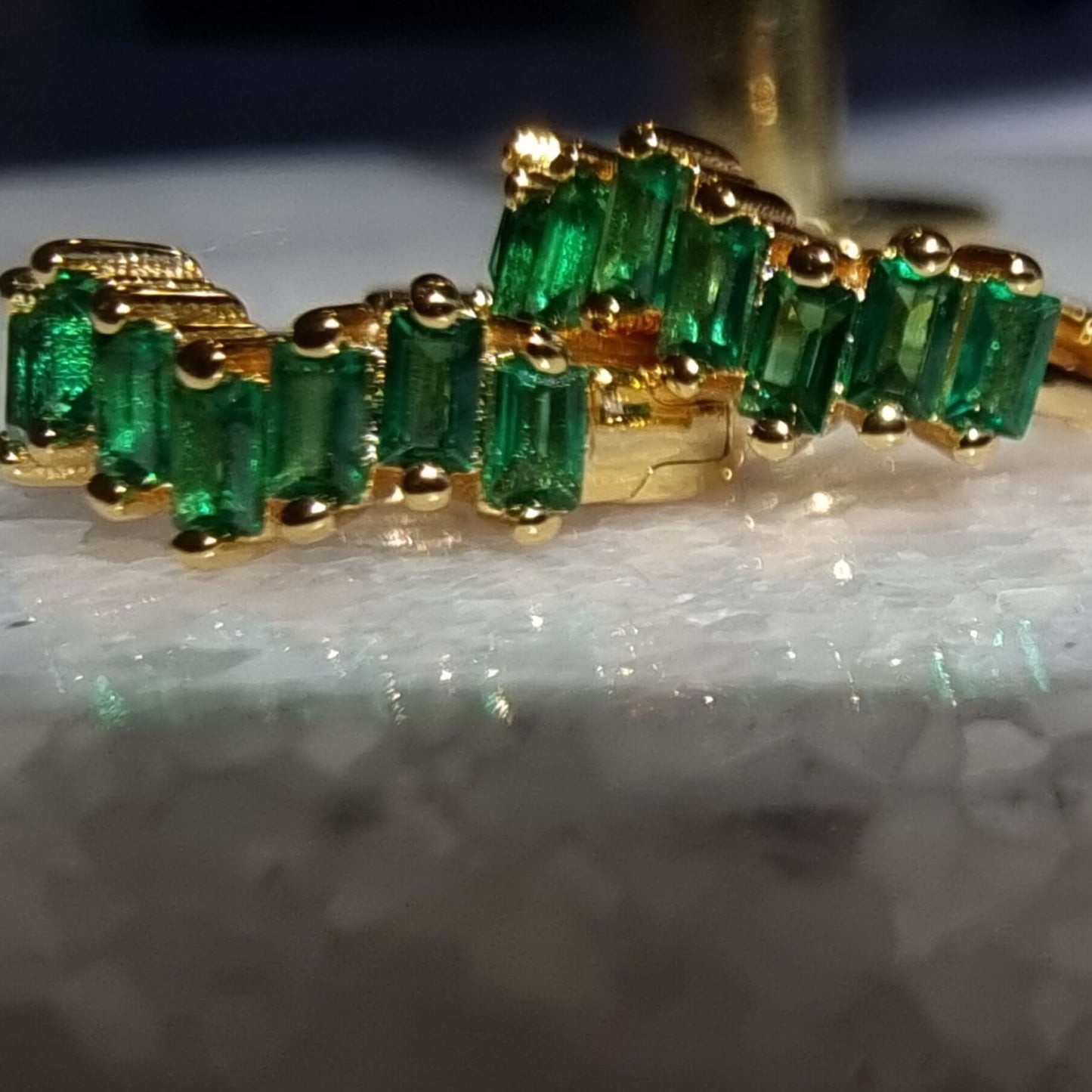 Detailed image of huggie earrings featuring a brilliant emerald green 5A zirconia stone set in 18K gold-plated sterling silver, ideal for everyday elegance.