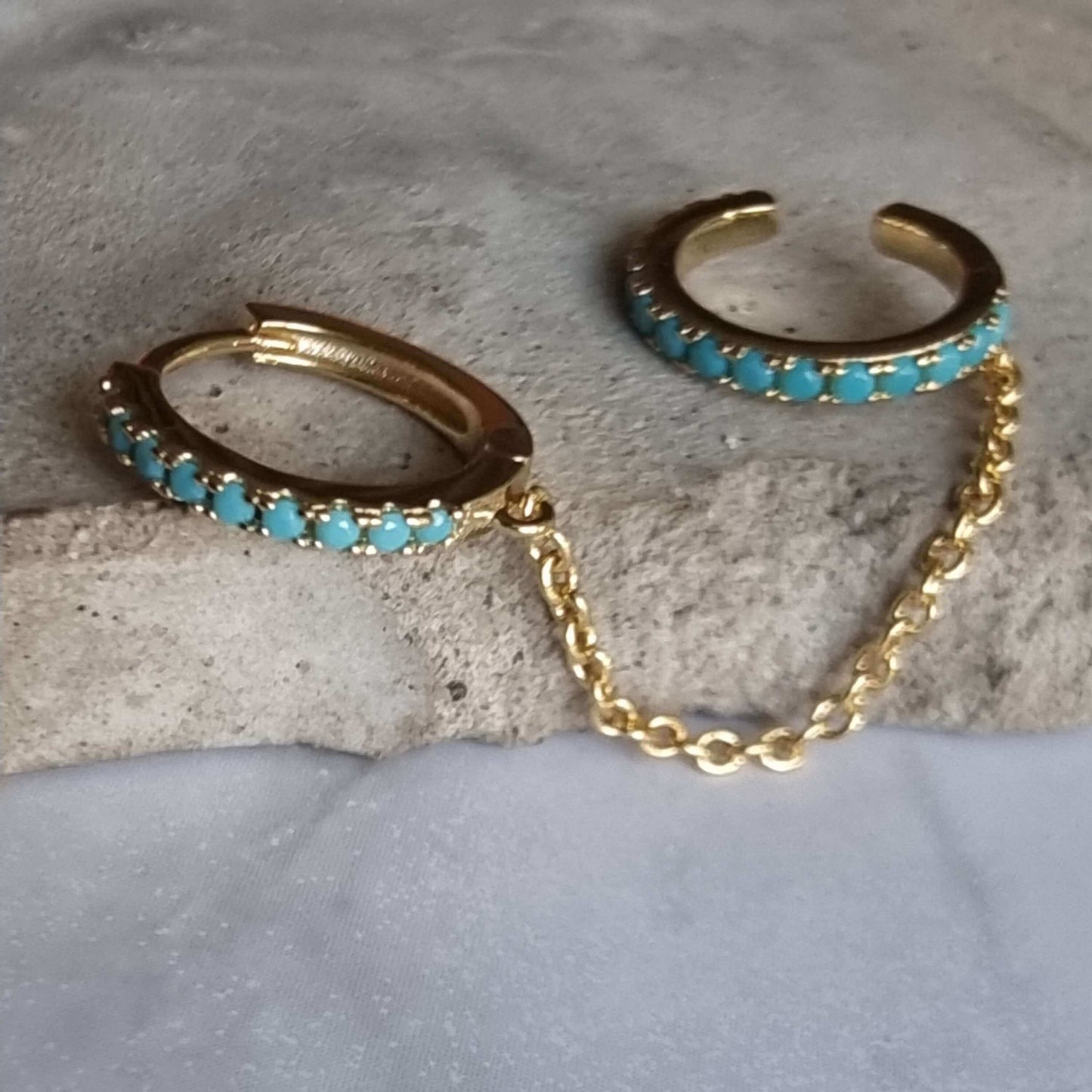 Close-up of turquoise zirconia hoop to cuff earring made from 18K gold-plated sterling silver, showing intricate chain detail and vibrant stone color.
