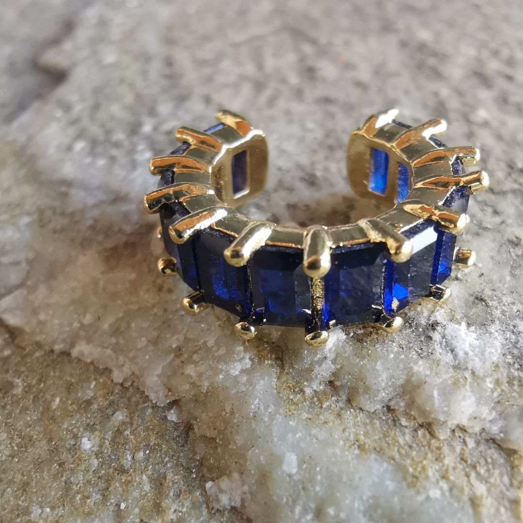 Elegant 18K gold-plated conch ear cuff with deep blue cubic zirconia, perfect for stacking or wearing solo without a piercing.