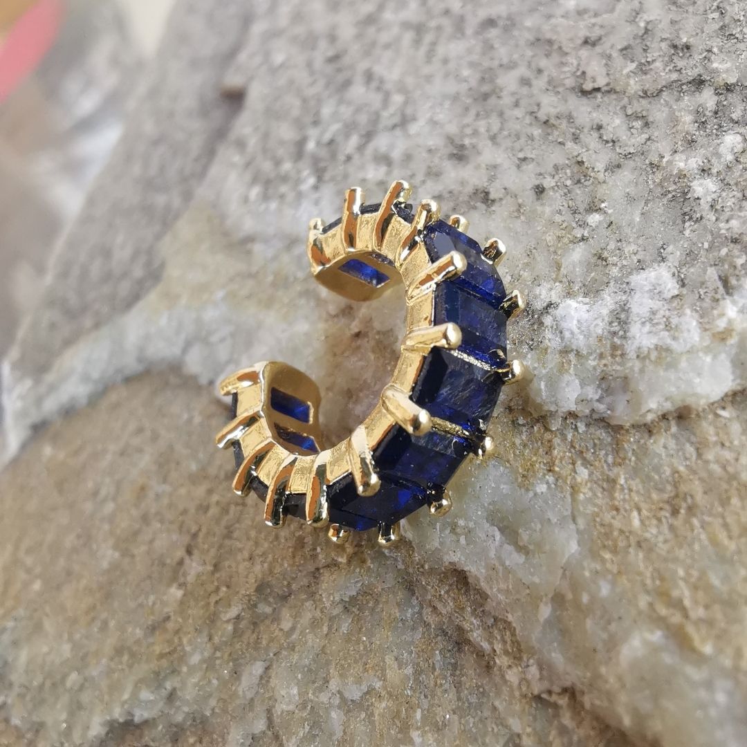 Close-up of 18K gold-plated ear cuff with bold blue zirconia, designed for the conch area and crafted for non-pierced ears.