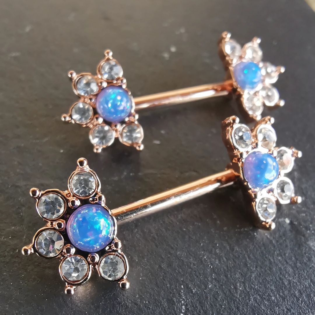 Gold mandala flower nipple bar piercing with a blue stone and sparkling CZ, crafted from 14G surgical steel 316L