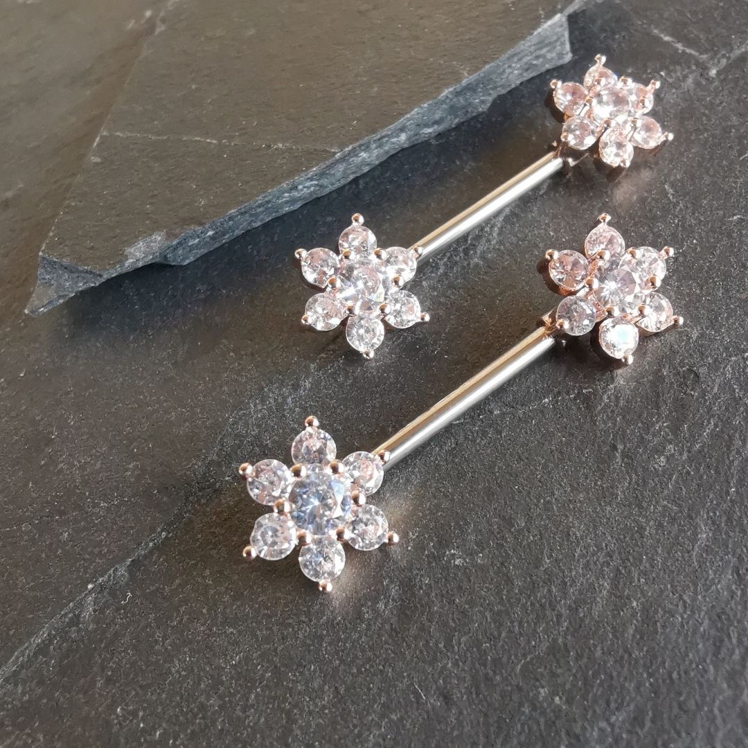 Elegant flower-shaped nipple bar piercing in rose gold with cubic zirconia, crafted from surgical steel 316L.