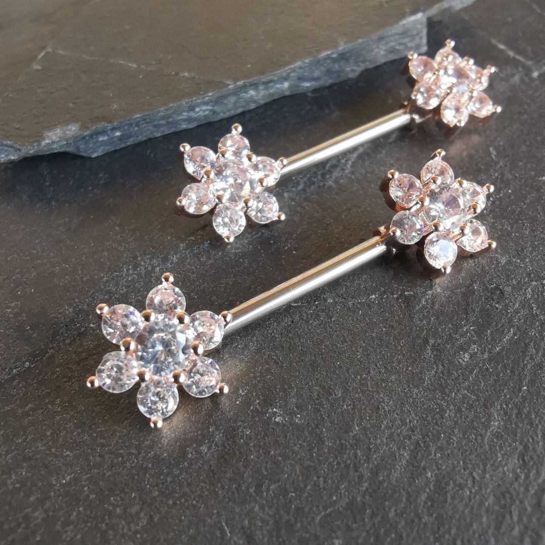 Flower nipple bar piercing with sparkling cubic zirconia, made from 14G rose gold surgical steel 316L.
