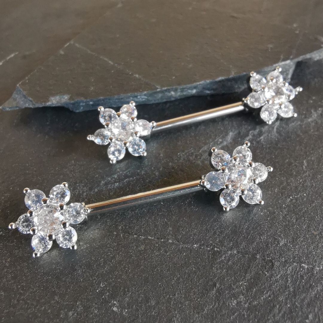 Flower nipple bar piercing with cubic zirconia accents, made from 14G silver surgical steel 316L