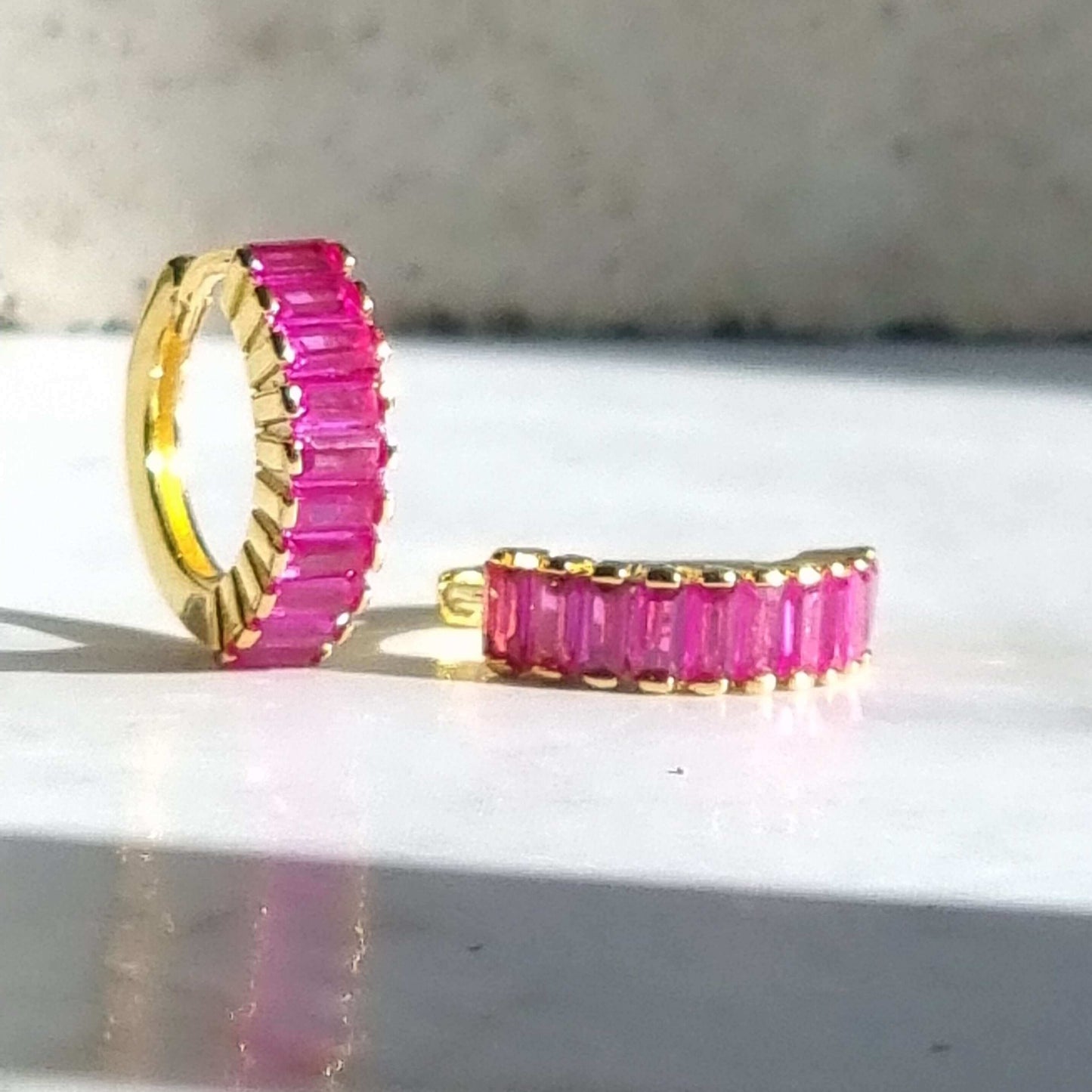 Vibrant magenta zirconia huggie hoops in 18K gold-plated sterling silver, perfect for bold ear stacks or elegant solo wear.