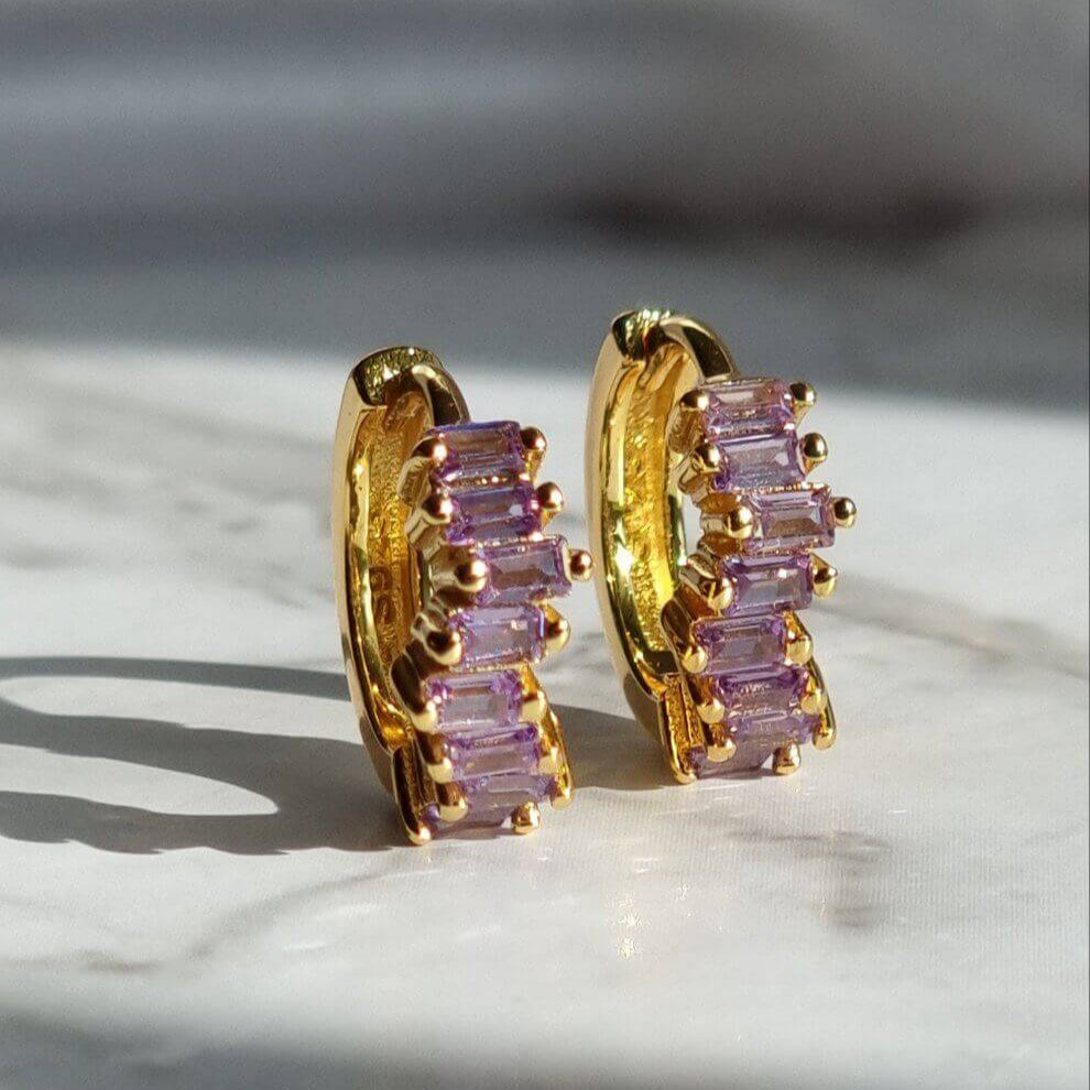 Lilac purple cubic zirconia huggie earrings crafted in 18K gold-plated 925 sterling silver, featuring rectangular stones and a sleek minimalist hoop design.