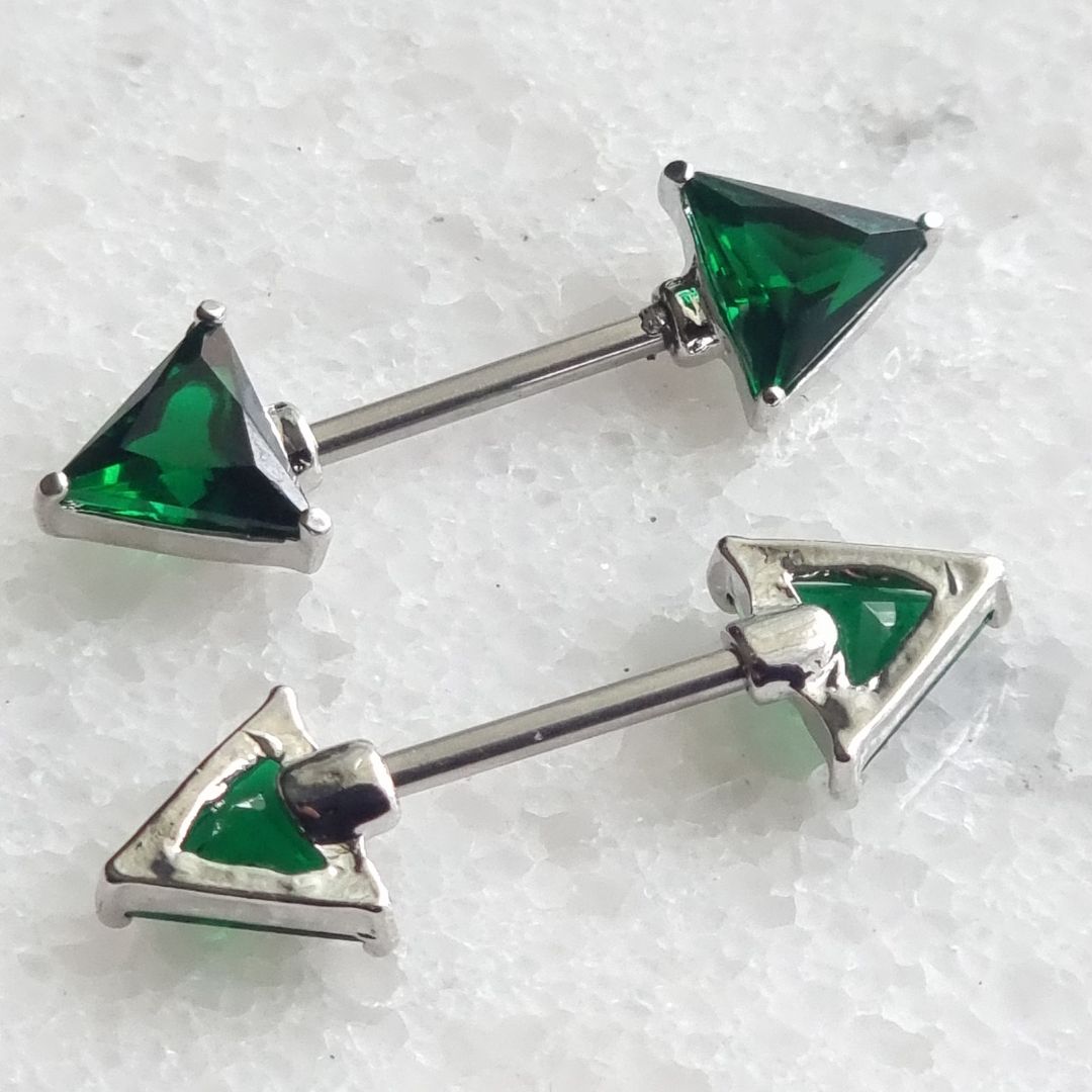Triangle nipple bar piercing with green gemstones and CZ, made from 14G surgical steel 316L.