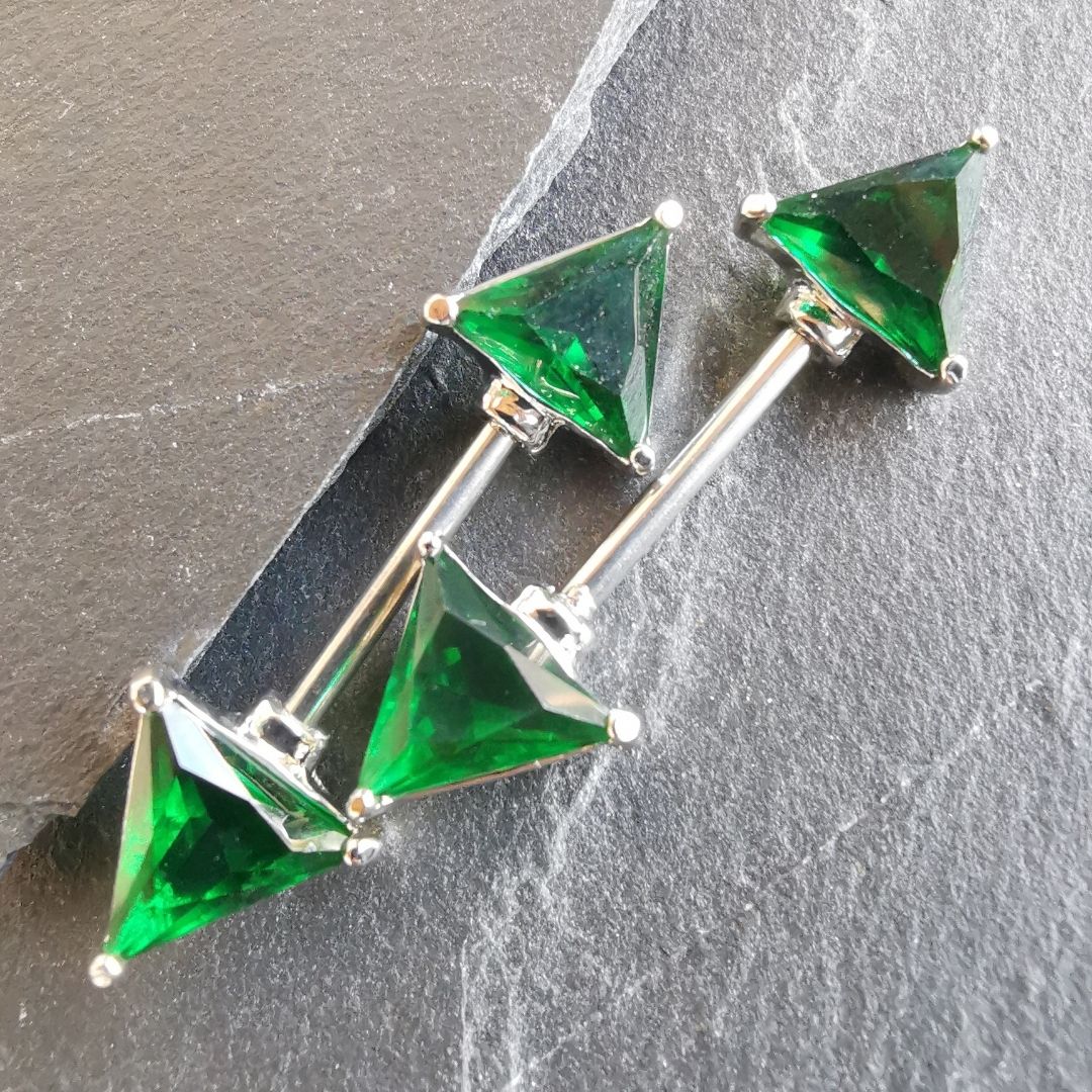 14G surgical steel triangle nipple bar with green gem centerpiece and cubic zirconia details.