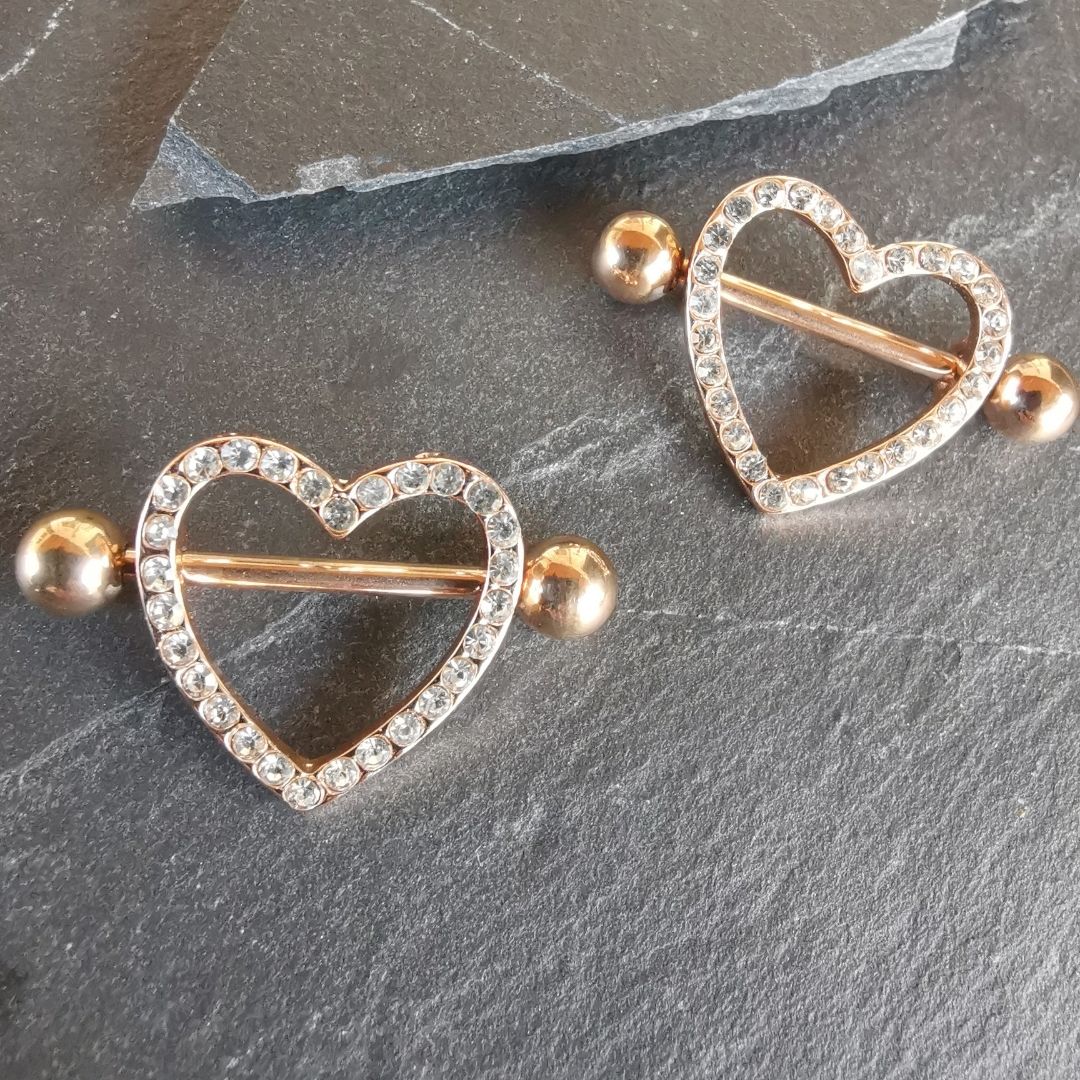 Elegant heart nipple piercing shield bars in 14G rose gold surgical steel 316L.