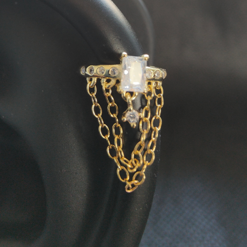 Angled view of helix hook ear piercing with elegant chains and zirconia embellishments, blending bold gold with refined sterling silver.