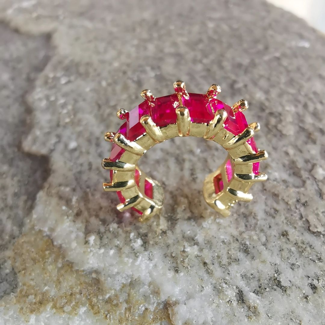 Non-piercing conch ear cuff earring in polished gold finish, showcasing a magenta cubic zirconia and made with lightweight gold-plated copper.