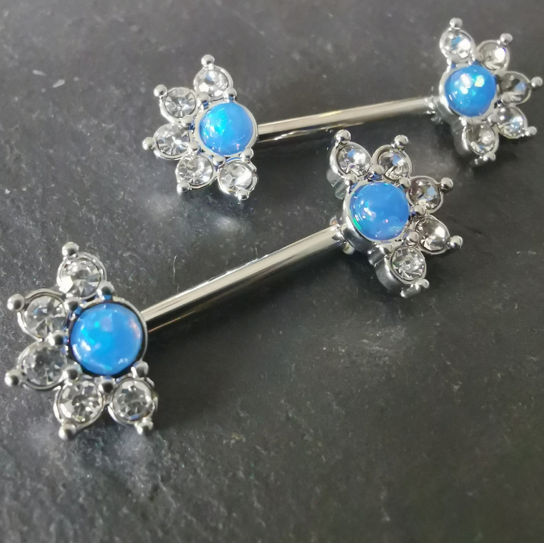 14G silver surgical steel nipple bar featuring a mandala flower design with a blue stone and CZ accents