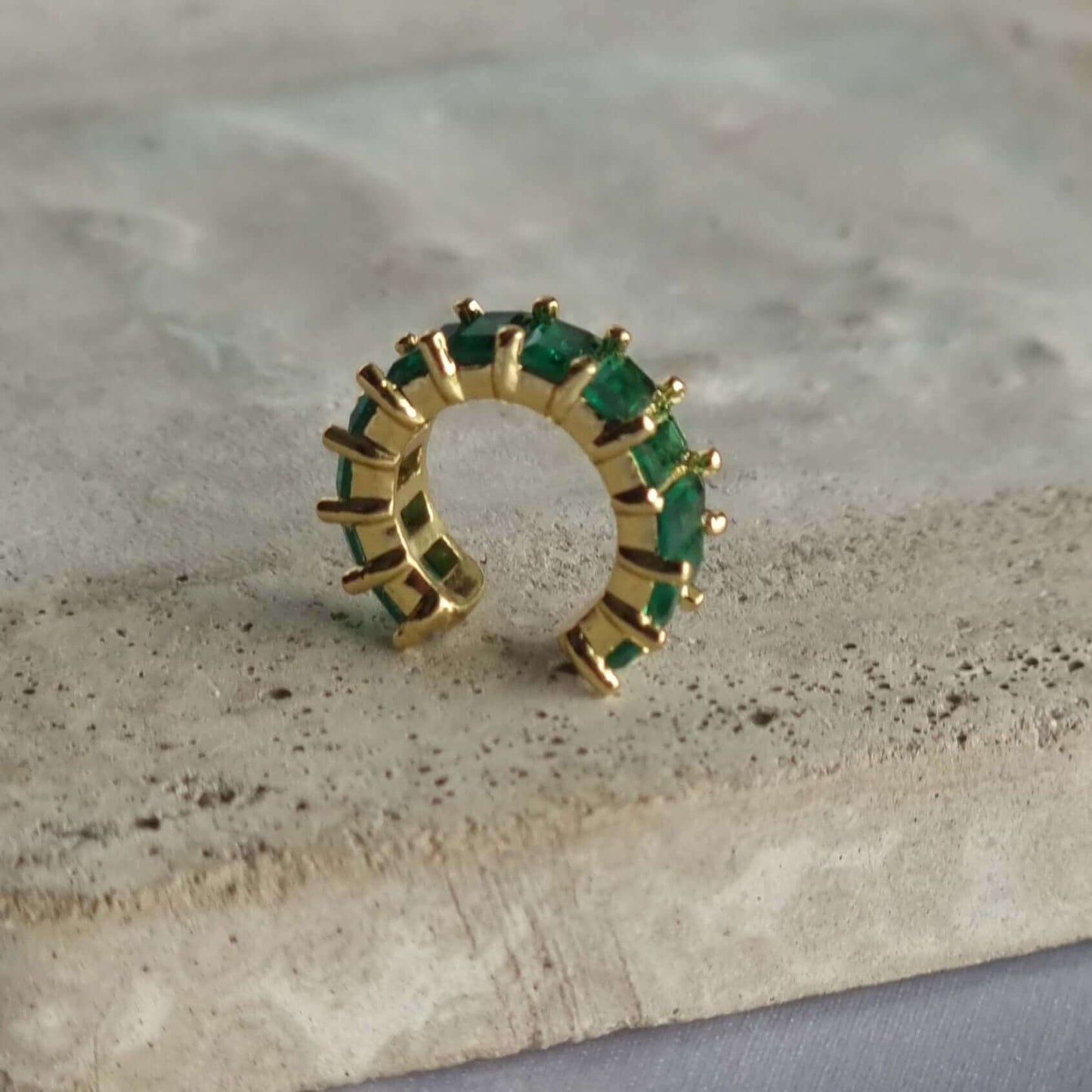 Non-pierced conch ear cuff earring made of 18K gold-plated copper with a sparkling green zirconia, offering trendy and secure ear styling.