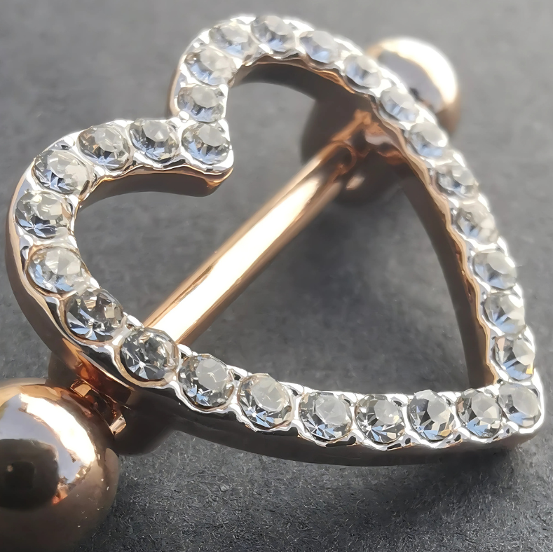 Elegant heart-shaped nipple piercing shields in 316L rose gold surgical steel for a bold, unique look.