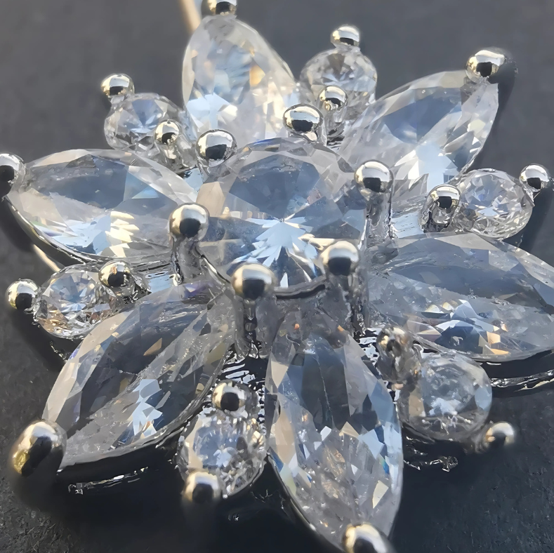 Silver flower motif end on a 14G surgical steel navel barbell for belly piercing.
