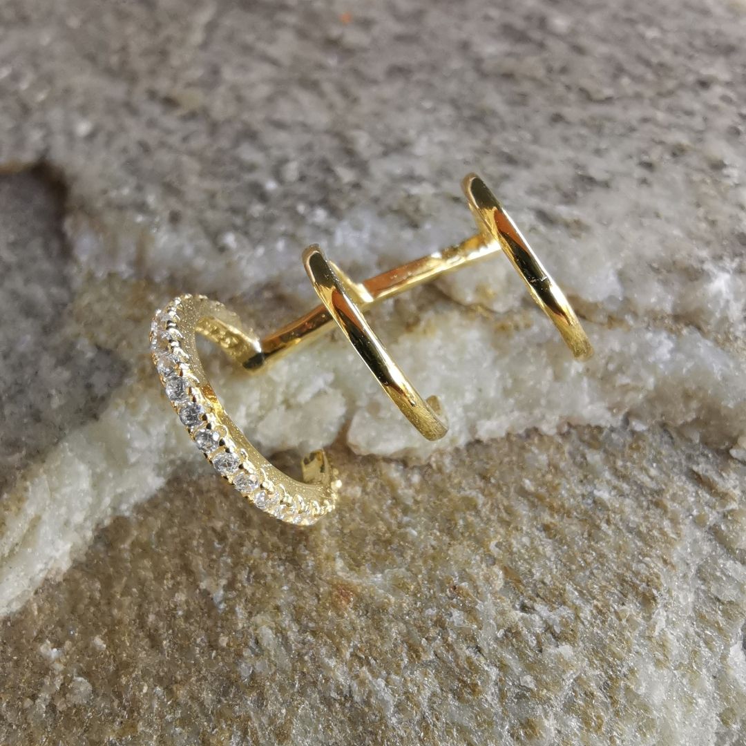 Modern ear cuff featuring three layered hoops in 925 sterling silver with an 18K gold plated finish, offering an adjustable, no-piercing design.