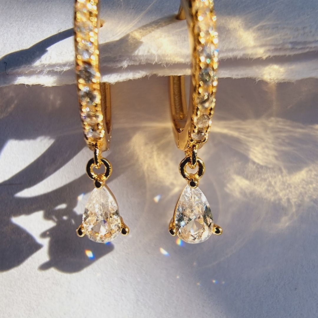Stunning white zirconia droplet ear piercings designed with a sleek 18K gold plated sterling silver finish.