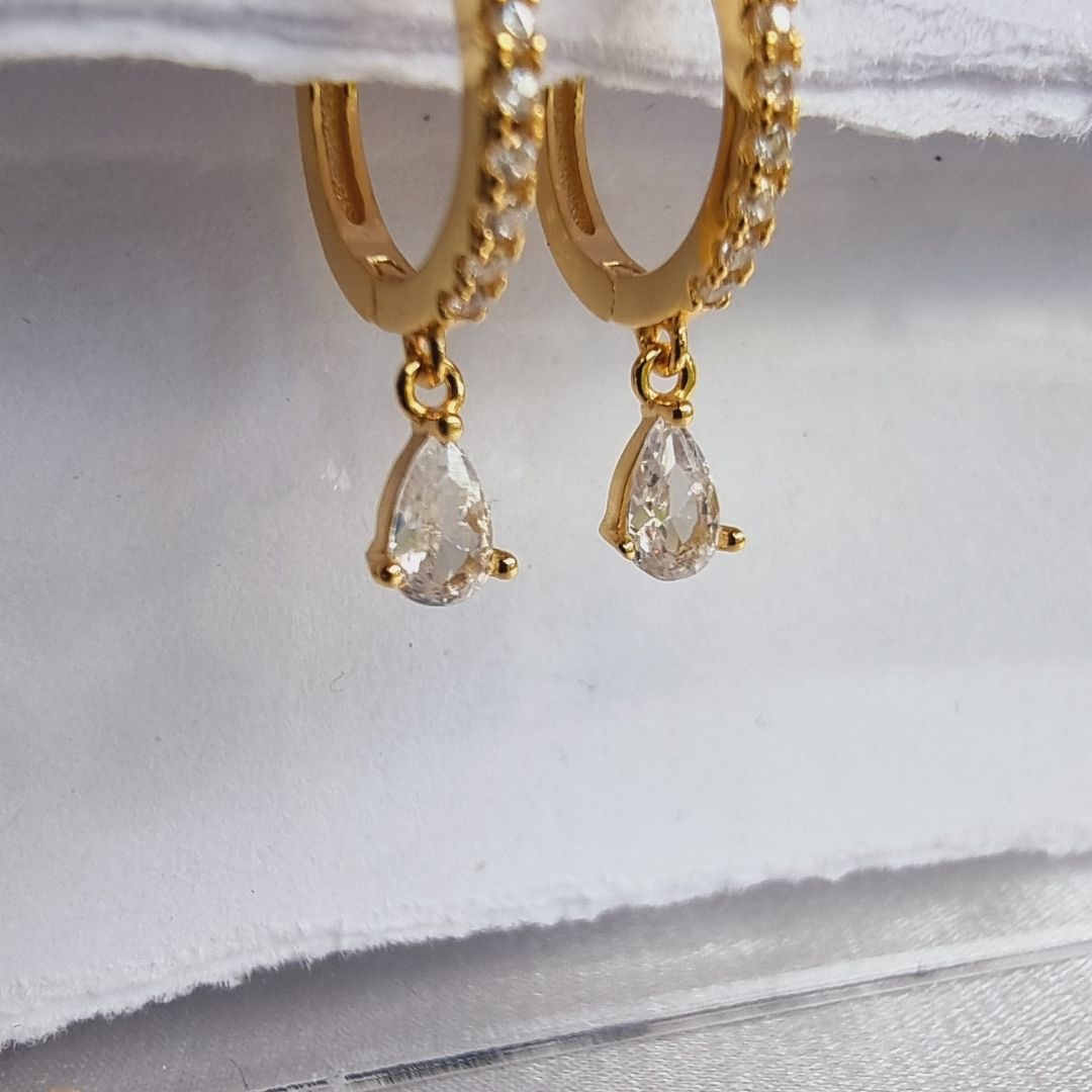 Stunning white zirconia droplet ear piercings designed with a sleek 18K gold plated sterling silver finish.