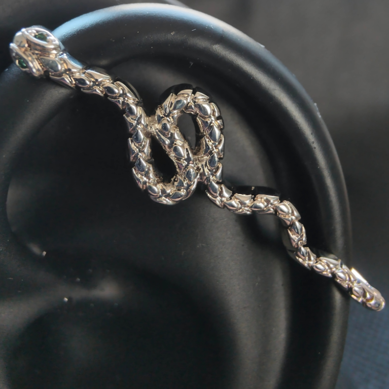Close-up of silver snake ear cuff with bar-style silhouette, made from silver-plated brass and designed to wrap the ear without a piercing.