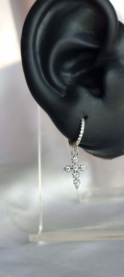 Silver earrings with cross decorated with cubic zirconia on ear