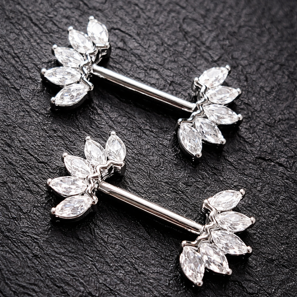 Two silver nipple barbells with crown design on a dark textured background