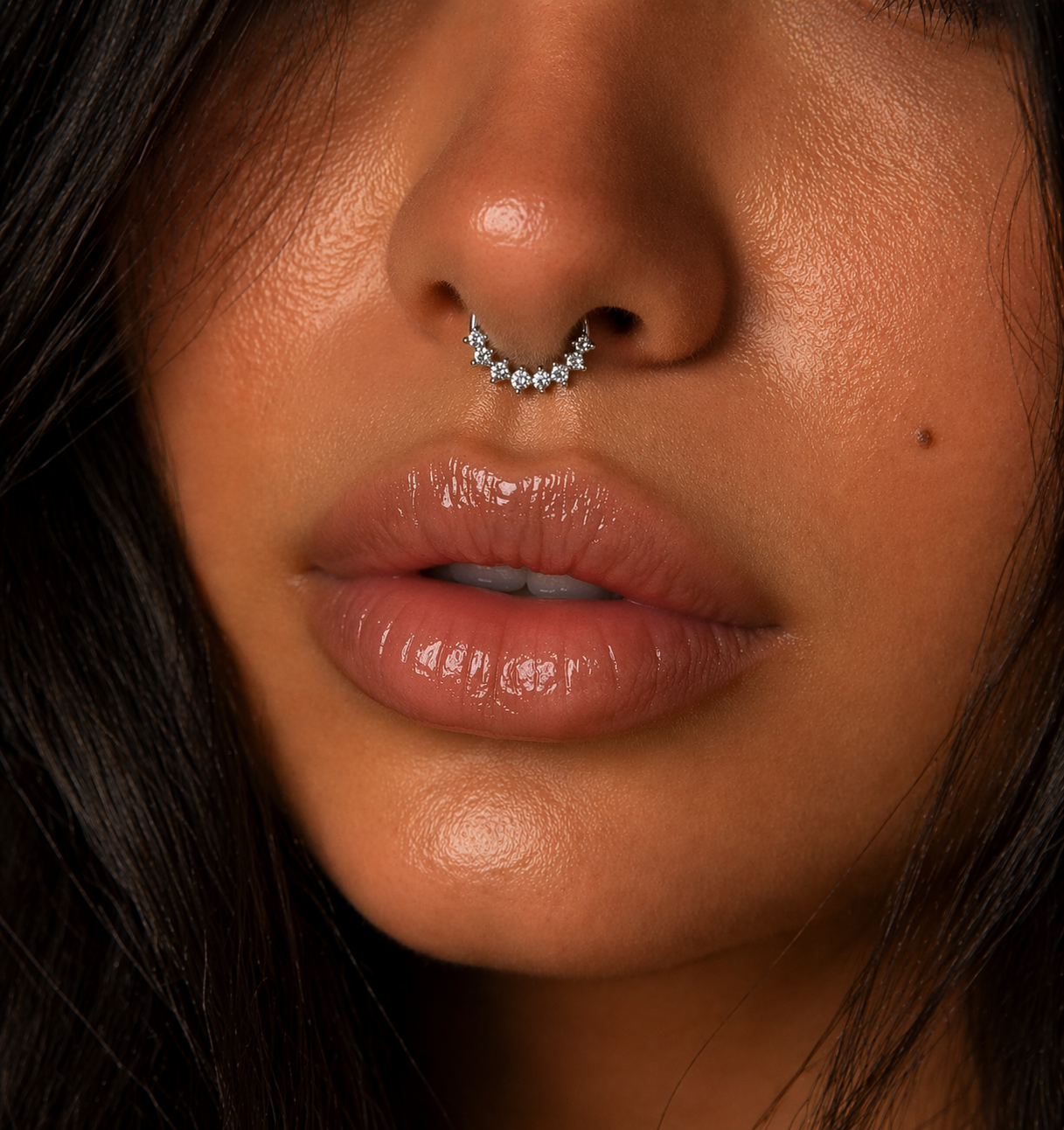 Close-up of a person's nose with a septum ring and lips.