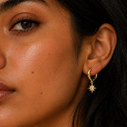 Close-up of a woman wearing a gold earring with a star design.