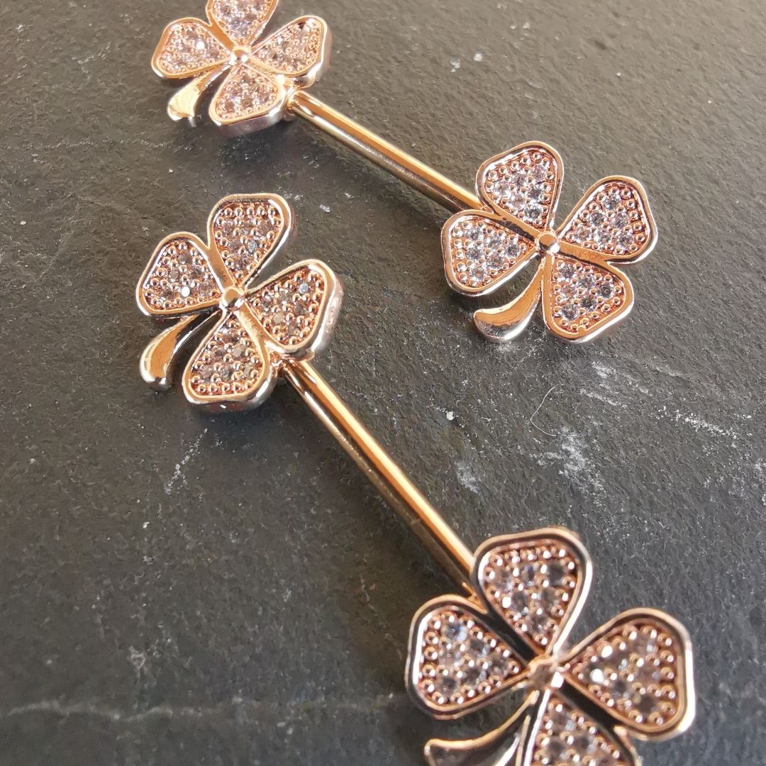 Rose gold clover leaf nipple bar jewelry featuring sparkling CZ stones, made from 14G surgical steel.