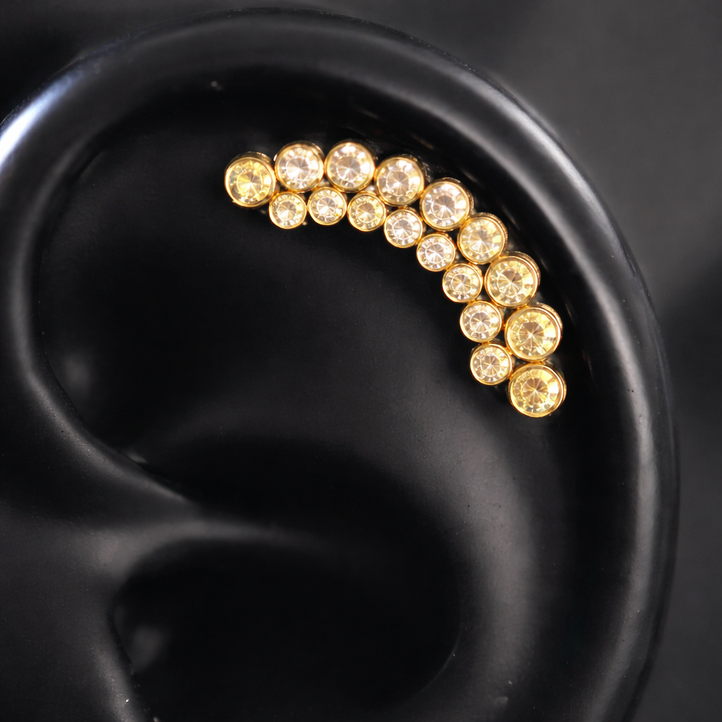 Gold earring with embedded stones on a black ear model