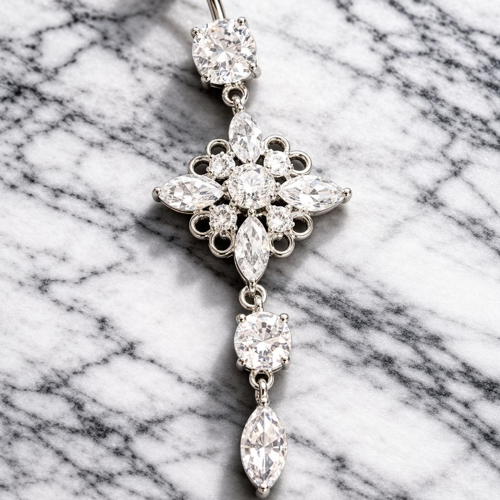 Decorative belly button ring with floral design on a marble background