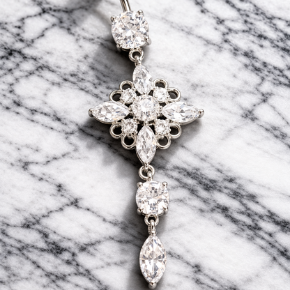 Decorative belly button ring with floral design on a marble background