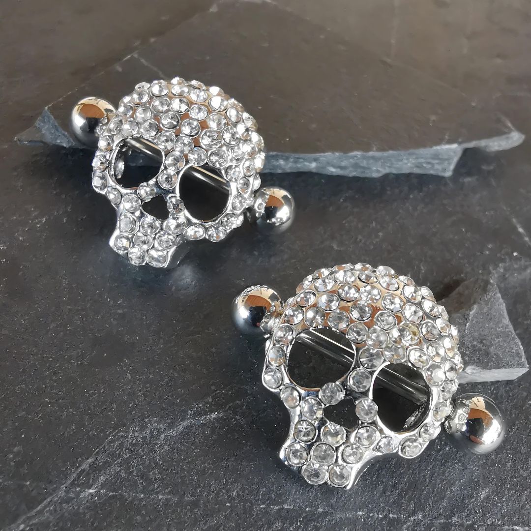 Diamond skull-shaped silver nipple bar shields, crafted from 16G surgical steel 316L, for piercing body jewelry.