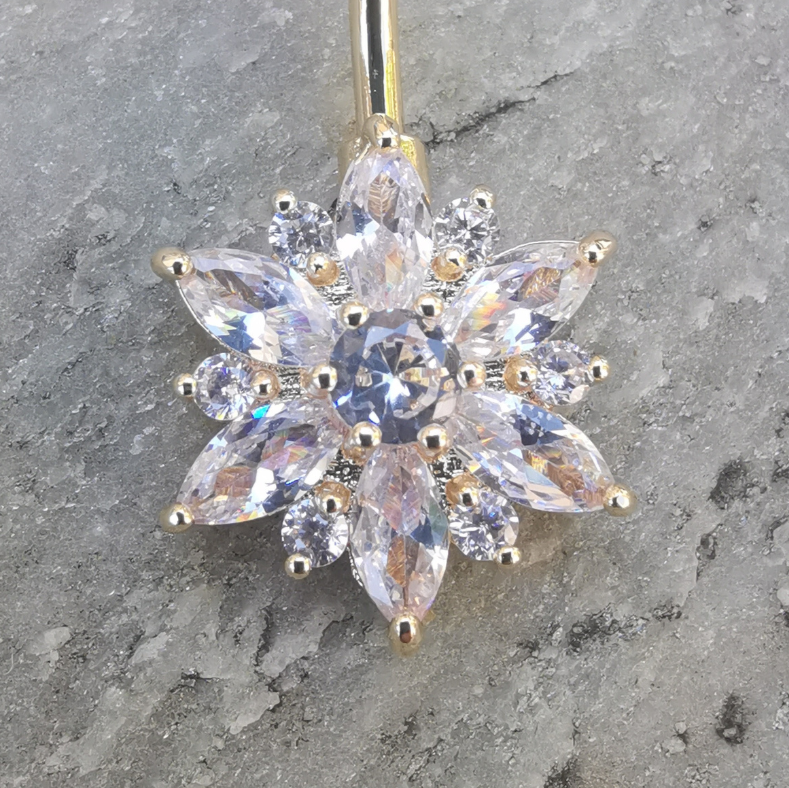 Sleek 14 gauge gold belly button ring crafted from 316L surgical steel, adorned with a white flower.