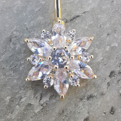 Sleek 14 gauge gold belly button ring crafted from 316L surgical steel, adorned with a white flower.