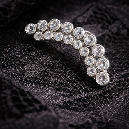 Silver earring with clear gemstones on a black textured background