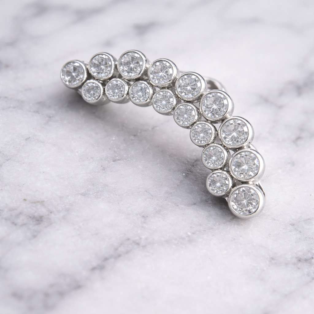 Silver earring with clear gemstones on a marble background