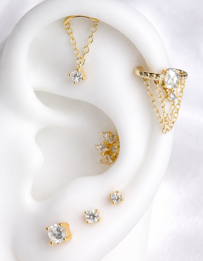 Gold earrings displayed on a white ear model