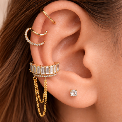 Close-up of an ear with multiple gold and diamond earrings.