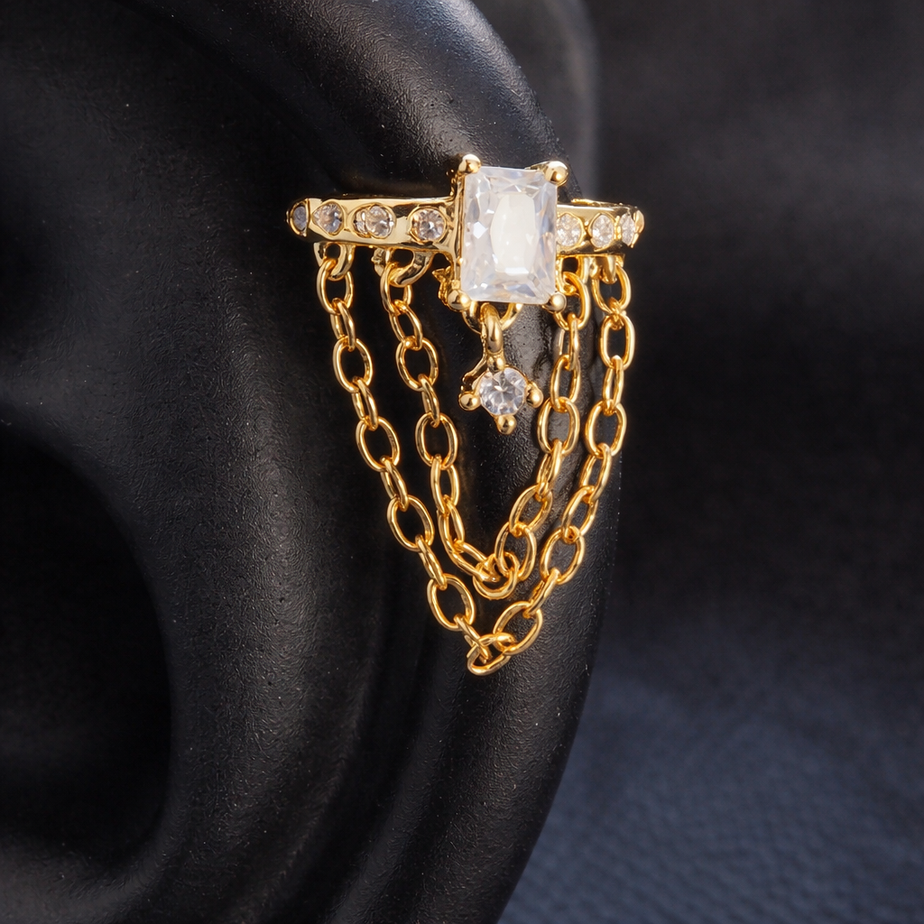 Gold ring with a large central gemstone and chain details on a dark background