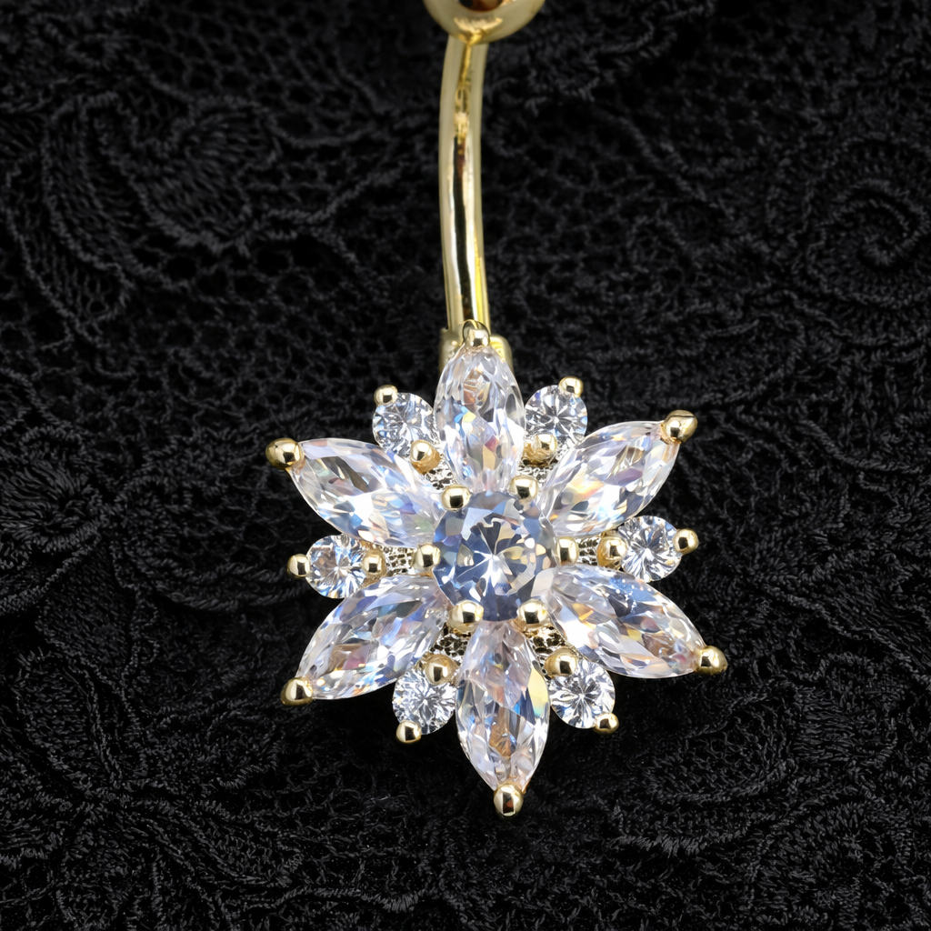 Gold belly button ring with a flower shaped clear gemstone on a black lace background