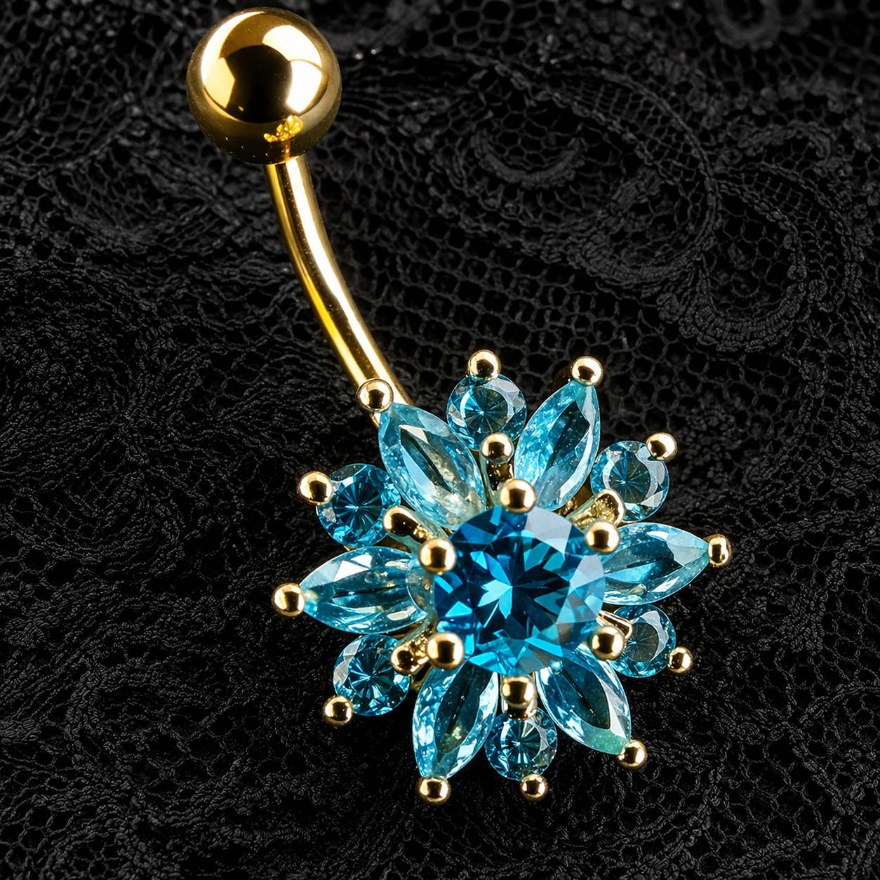 Gold belly button ring with blue gemstones on a black lace background