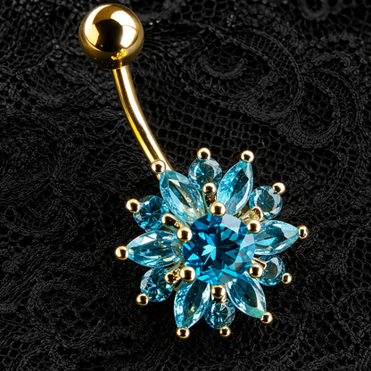 Gold belly button ring with blue gemstones on a black lace background