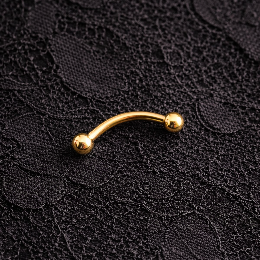Gold curved eyebrow/rook earring on black lace fabric
