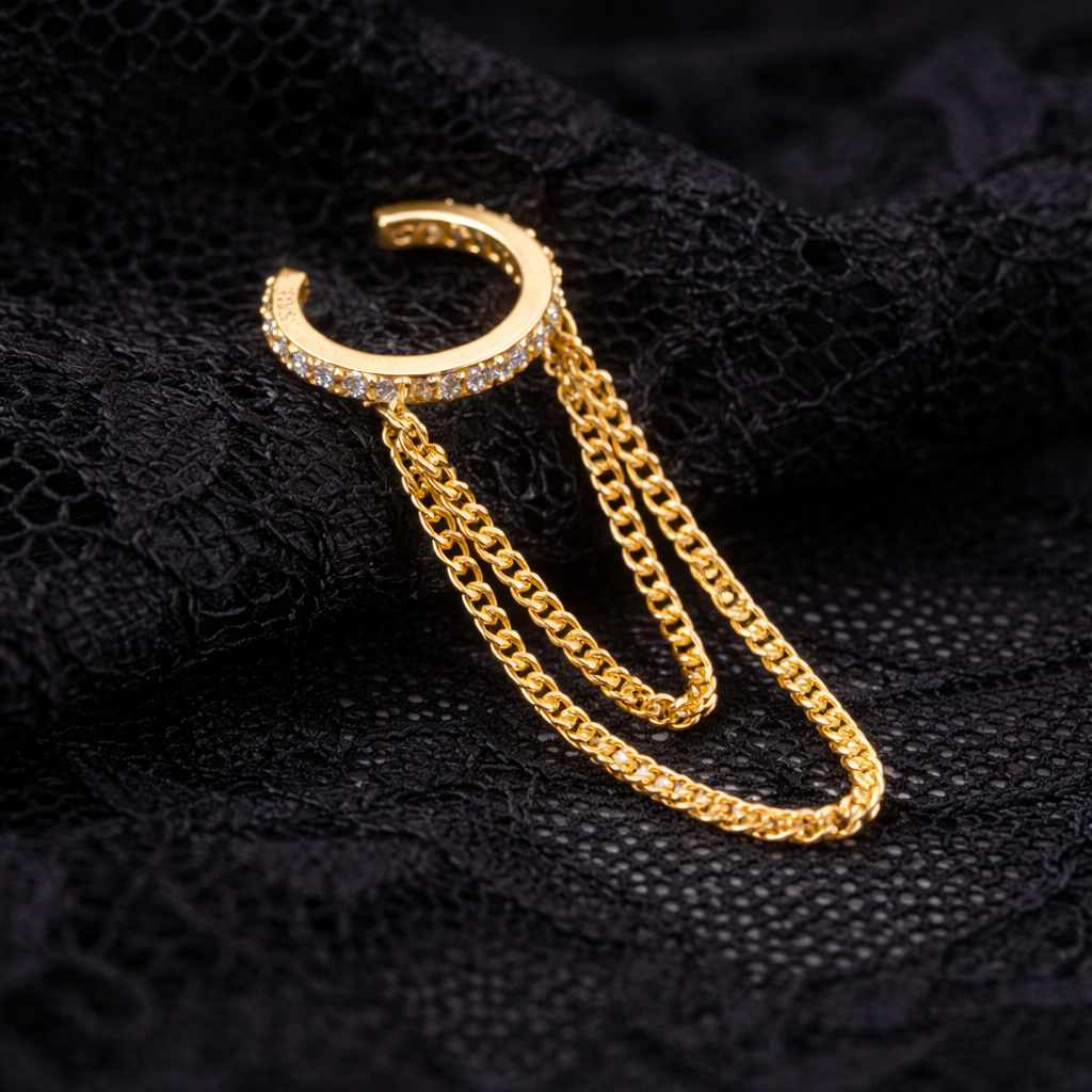 Gold hoop earring with chain on a black textured background