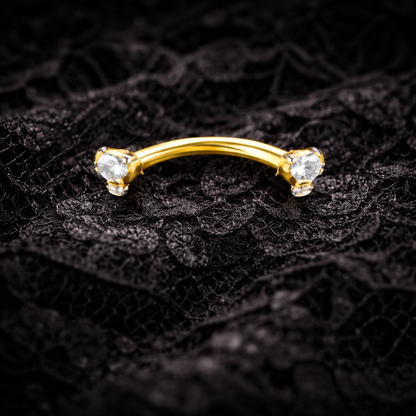 Gold eyebrow bar with cubic zirconia on a black lace background