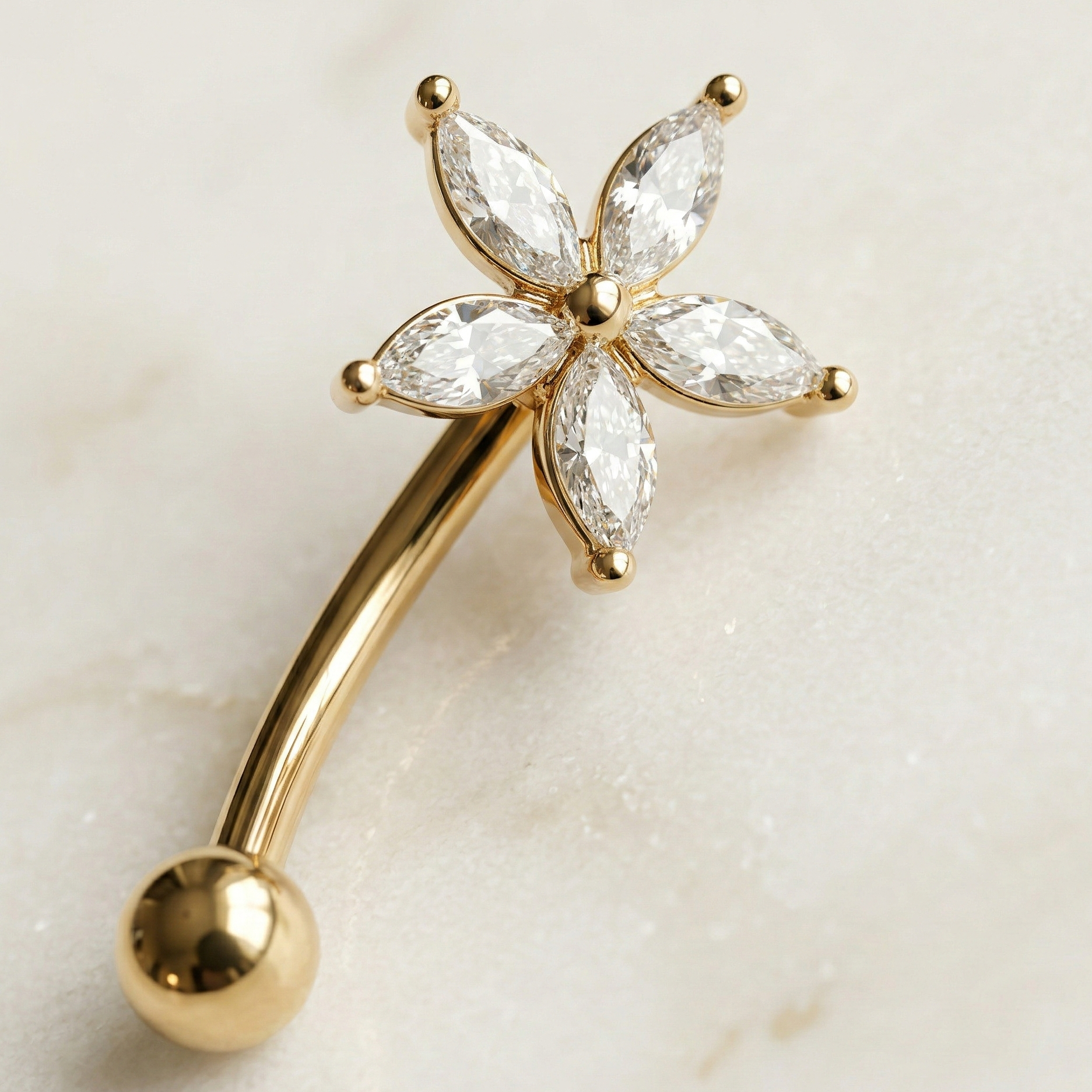 Gold eyebrow/rook bar with star diamond-like stones on a light background