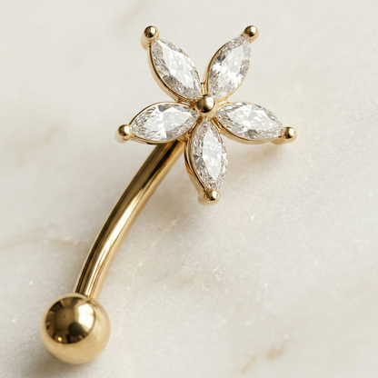 Gold eyebrow/rook bar with star diamond-like stones on a light background