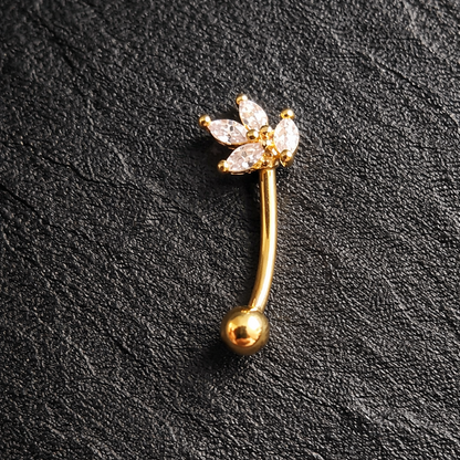 Gold eyebrow/rook barbell with floral design on a black textured background